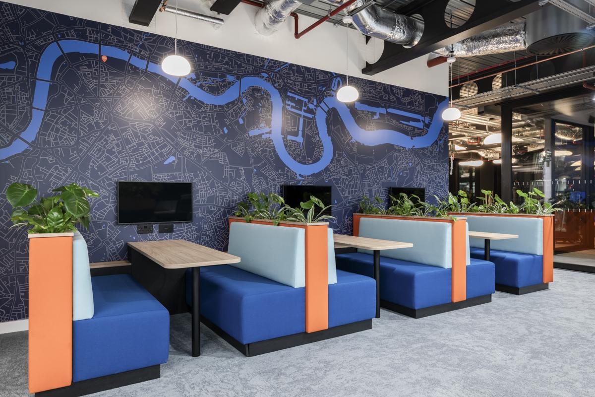 Modern office lounge with blue mural and booth seating